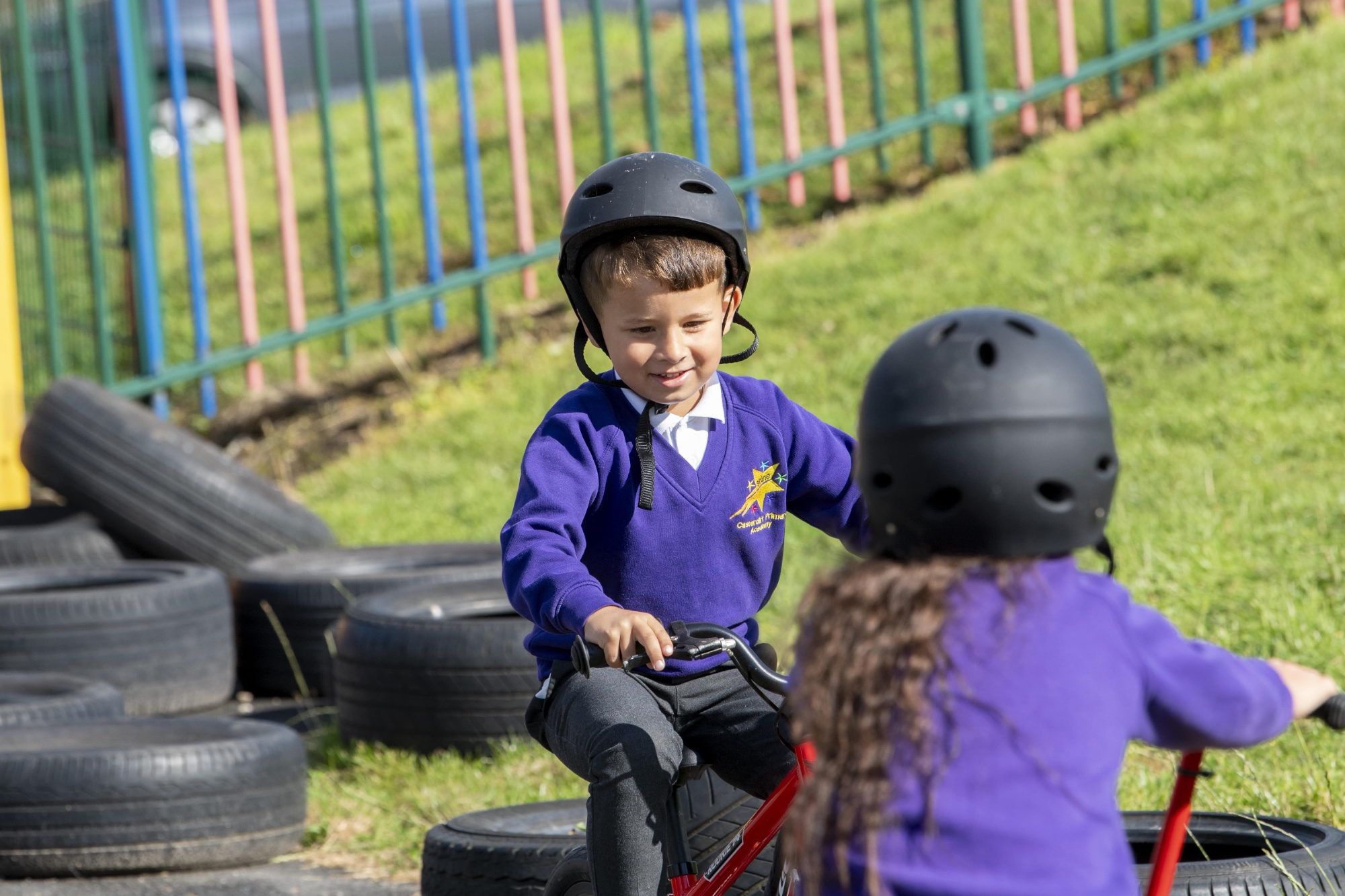 Two children in black helmets riding bikes